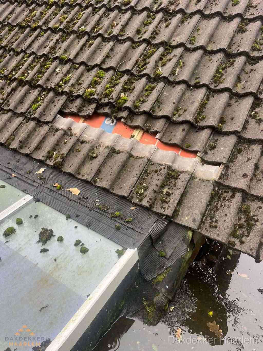 Beschadigd pannendak met ontbrekende dakpannen voor reparatie in Haarlem