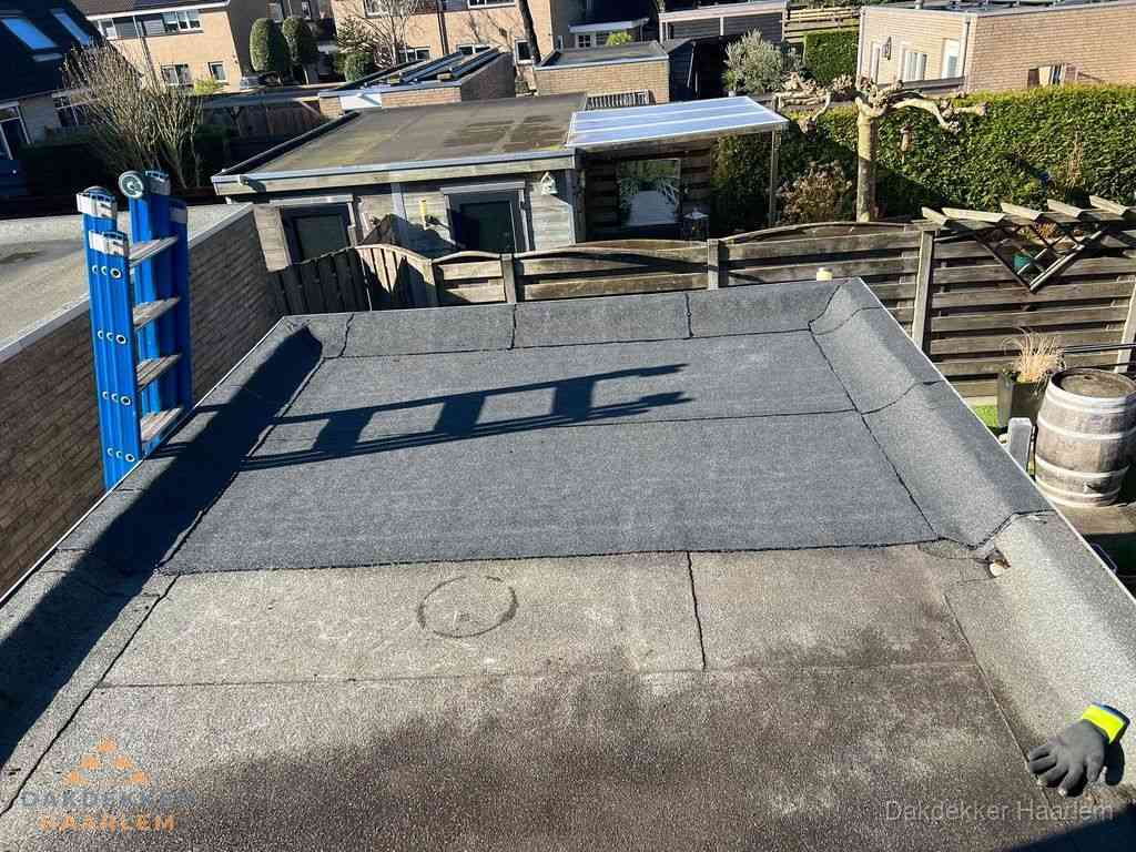 Dakdekker legt onderlaag op plat dak met houten constructie in Haarlem