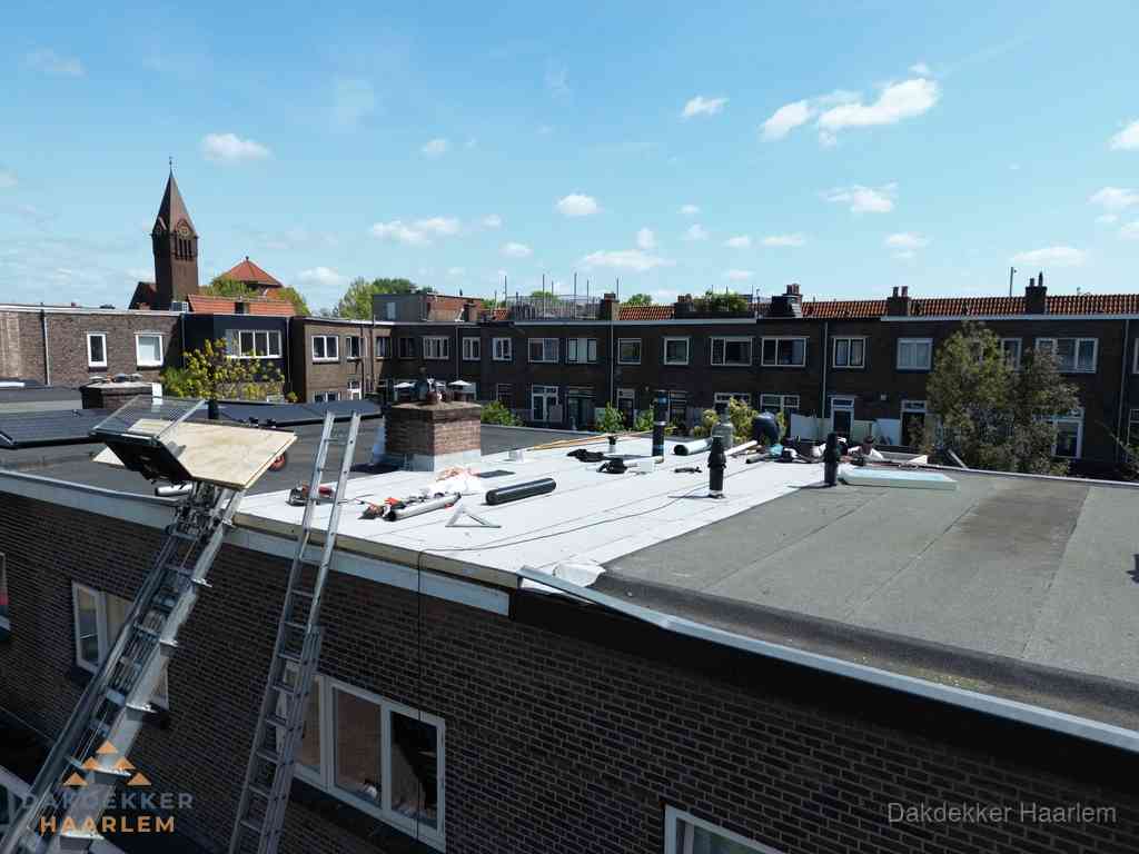Dakdekkers aan het werk op plat dak in Haarlem