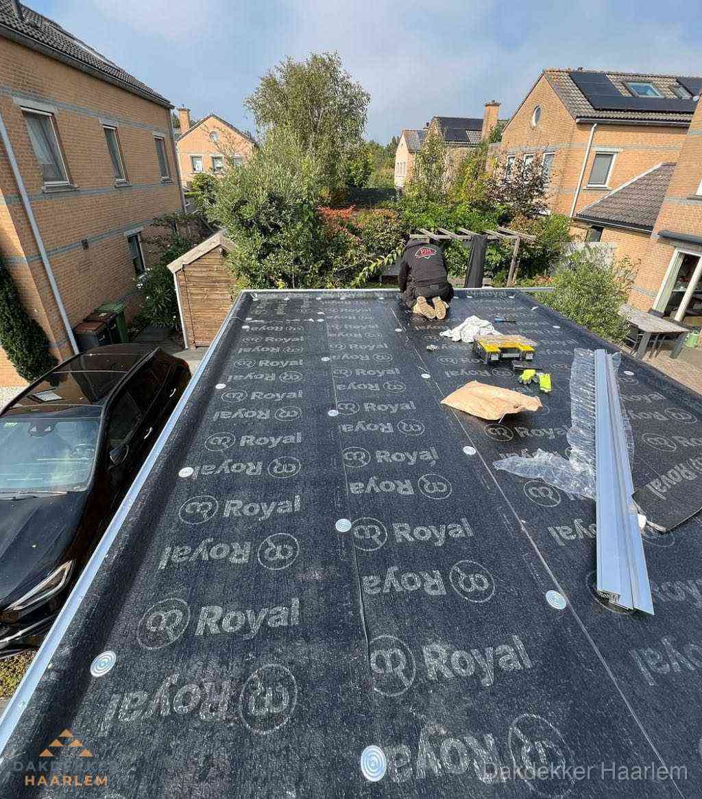 Dakdekker aan het werk op plat dak renovatie in Haarlem