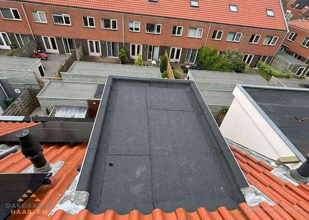 Plat dak met bitumen bedekking naast dakkapel in Haarlem