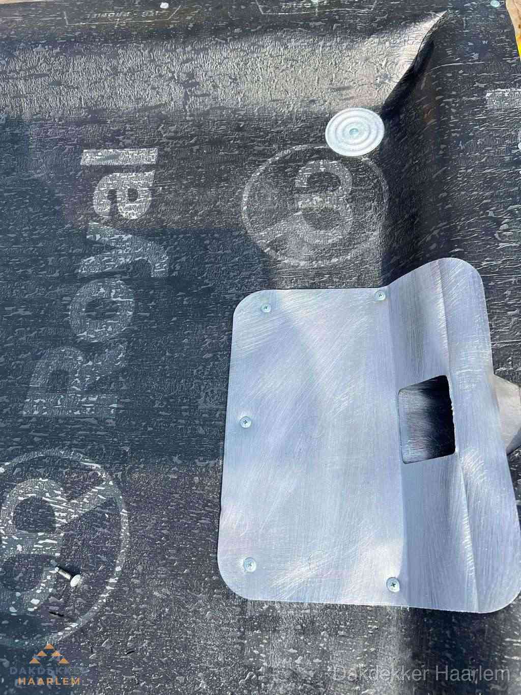 Dakdoorvoer met metalen afvoerplaat op bitumen dak in Haarlem
