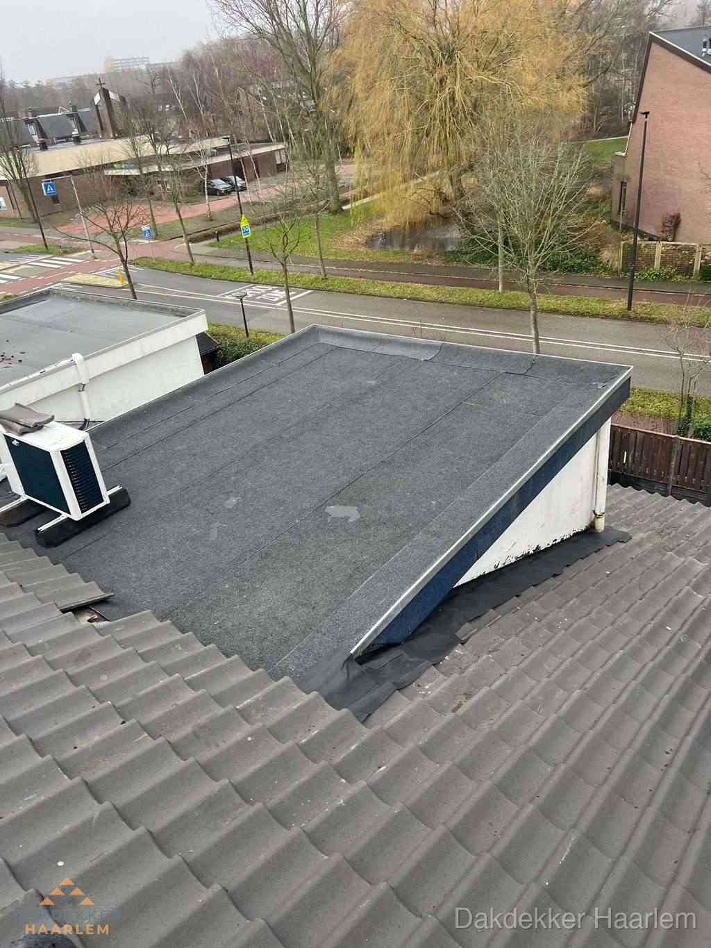 Plat dak met bitumen dakbedekking naast schuin pannendak in Haarlem