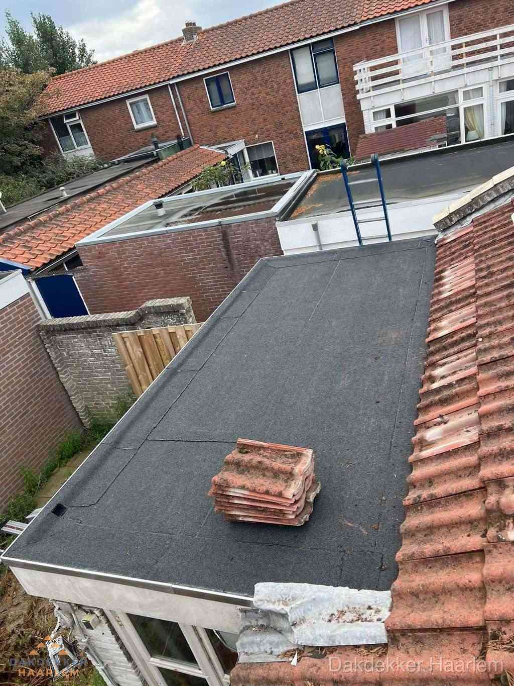 Aanbouw plat dak met reservepannen voor dakpannen vervangen in Haarlem